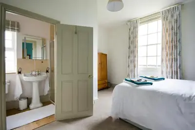 a bedroom with a bed and a bathroom with a sink at Wilde Lodge by Birch Stays in Bucknell