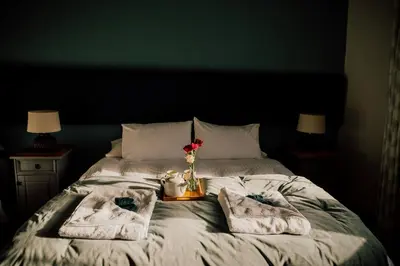 a bed with towels and a vase of flowers on it at Wilde Lodge by Birch Stays in Bucknell