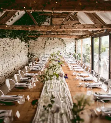 a long table with white chairs and flowers in a room at Wilde Lodge by Birch Stays in Bucknell