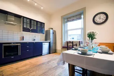 a kitchen with a table and a clock on the wall at Wilde Lodge by Birch Stays in Bucknell
