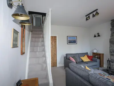 a living room with a couch and a staircase at Gwelfor in Harlech