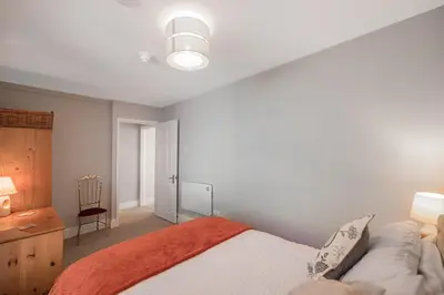 a bedroom with a bed and a desk and a chair at Spacious 3 Bedroom Sea View Flat in Aberdyfi