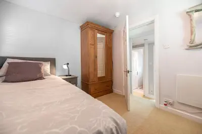 a bedroom with a bed and a door to a bathroom at Spacious 3 Bedroom Sea View Flat in Aberdyfi