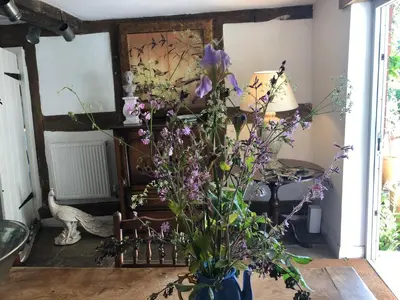 a vase filled with purple flowers in a room at Logaston Common Farmhouse in Woonton