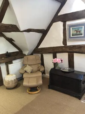 a attic room with a chair and a table at Logaston Common Farmhouse in Woonton