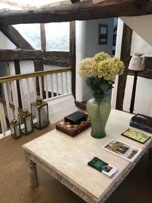 a table with a vase of flowers on it at Logaston Common Farmhouse in Woonton