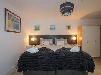 a bedroom with a large bed with two towels on it at Sandcastles in Barmouth