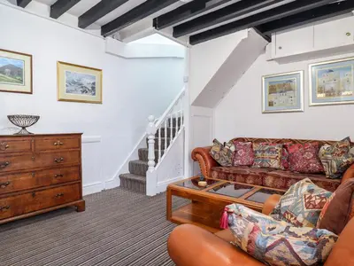 a living room with a couch and a dresser at The Courtyard Cottage in Llangollen