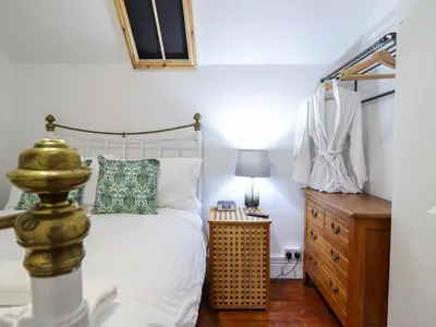 a bedroom with a bed and a wooden dresser at The Courtyard Cottage in Llangollen
