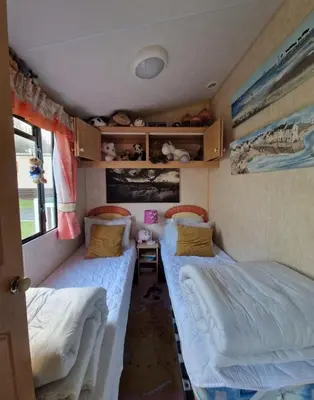 a small room with two beds in a trailer at 2 Bed Caravan - Sleeps 4 - Pets - Parking - Wifi in Aberystwyth