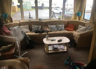 a living room with a couch and a table at 2 Bed Caravan - Sleeps 4 - Pets - Parking - Wifi in Aberystwyth