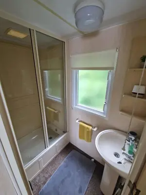 a bathroom with a shower and a sink and a mirror at 2 Bed Caravan - Sleeps 6 - Pets - Pool - Parking in Aberystwyth
