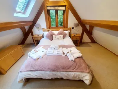 a bedroom with a large bed in a attic at Swn Y Nant Lodge with hot tub Brecon in Brecon