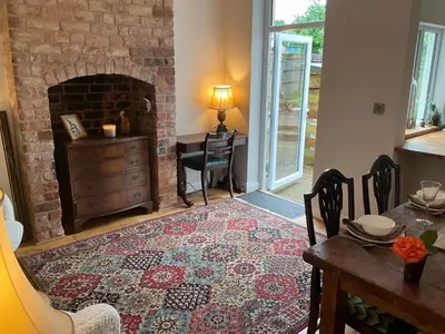a living room with a table and a brick fireplace at Little Hotspur in Shrewsbury