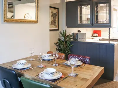 a wooden table with plates and wine glasses on it at Hafanedd in Dyffryn