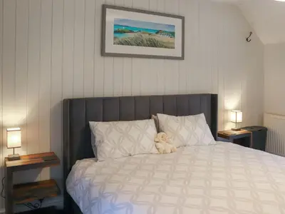 a stuffed teddy bear sitting on top of a bed at Hafanedd in Dyffryn