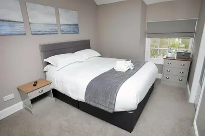 a bedroom with a large bed with white sheets and pillows at OYO Glyn Valley Hotel in Glyn-Ceiriog