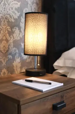 a lamp sitting on top of a table with a paper at OYO Glyn Valley Hotel in Glyn-Ceiriog