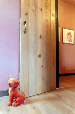 a teddy bear sitting on the floor next to a door at Old Chapel Llanfrynach in Brecon