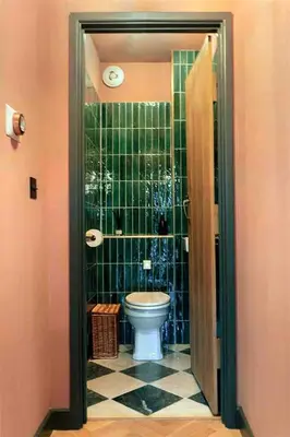 a bathroom with a toilet and green tiled walls at Old Chapel Llanfrynach in Brecon