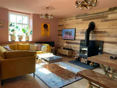 a living room with a couch and a stove at Old Chapel Llanfrynach in Brecon