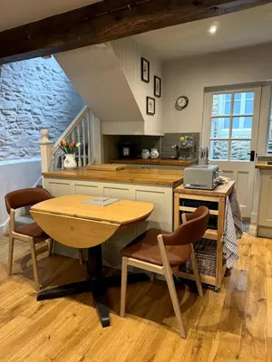 a kitchen with a table and chairs and a counter at The Cottage, Upper Linney, Ludlow in Ludlow