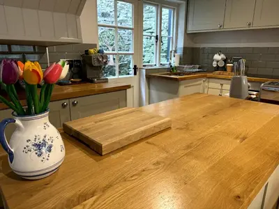 a kitchen with a vase of flowers on a wooden table at The Cottage, Upper Linney, Ludlow in Ludlow