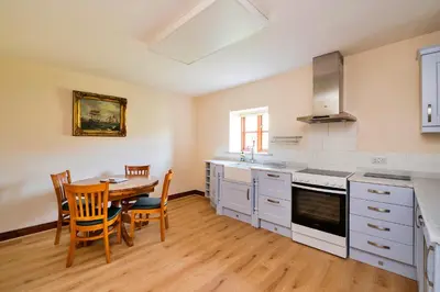 a kitchen with a table and a dining room at Finest Retreats - Walton Maisonette in Onibury