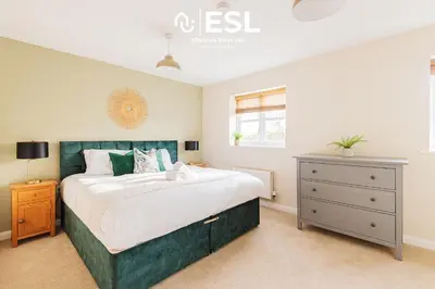 a bedroom with a large bed and a dresser at 4 bedroom house in Shrewsbury with parking in Shrewsbury