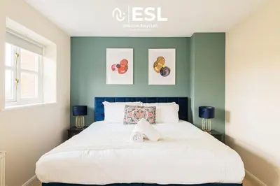 a bedroom with a large bed with blue walls at 4 bedroom house in Shrewsbury with parking in Shrewsbury