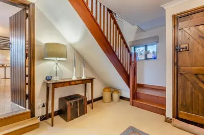 a hallway with a stairway with a wooden door at 3 Bed in Leominster oc-r30485 in Yarpole