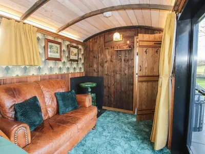 a living room with a brown couch in a room at GWR Wagon - Victoria Station in Craven Arms