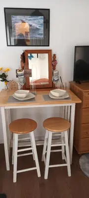 a table with two stools and a mirror at Robins nest in Great Hanwood