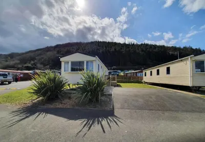 a building with plants in a parking lot at Pet Friendly 3 Bed Static Caravan in Clarach Bay Spacious and Cozy Stay in Aberystwyth