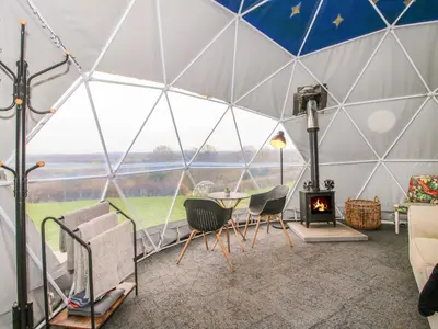 a tent with a table and chairs and a fireplace at Meadow View - Bryn-Mawr Retreat in Llanymynech
