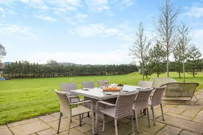 a table and chairs on a patio with a field at 4 Bed in Llansanffraid oc-k30383 in Llanymynech
