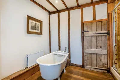 a bath tub in a room with a wooden door at 14 Bed in Llansanffraid oc-b30382 in Llanymynech