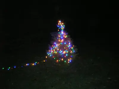 a christmas tree is lit up in the dark at Bevan House with Hot Tub in Mid-Wales in Hundred House