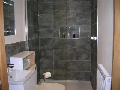 a bathroom with a shower with a toilet and a sink at River Lodge Hot Tub Sleeps 6 in Hundred House
