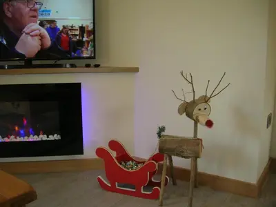 a living room with a tv and a reindeer in a sledge at River Lodge Hot Tub Sleeps 6 in Hundred House