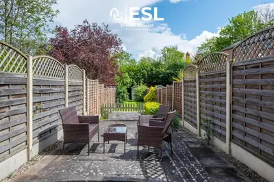 a row of chairs in a garden with fences at 2 Bed Townhouse with Garden & Parking in Shrewsbury