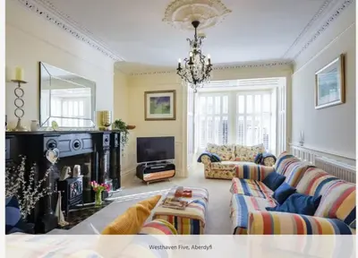 a living room with a couch and a fireplace at Westhaven 5 Beachfront Luxury-Free parking permit in Aberdyfi