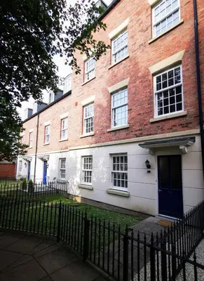 a brick building with a blue door and a fence at 2 bedroom apartment - Shrewsbury town centre in Shrewsbury