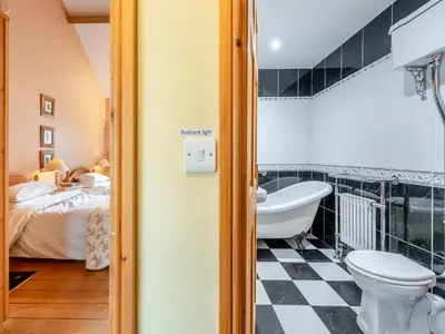 a bathroom with a toilet and a bath tub at Y Cartws in Llanybydder