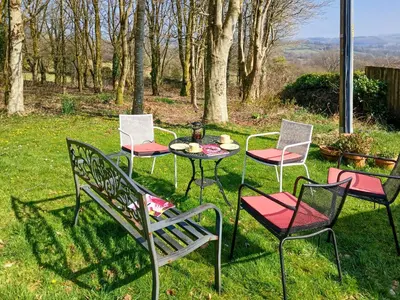 a group of chairs and a table in the grass at Y Cartws in Llanybydder