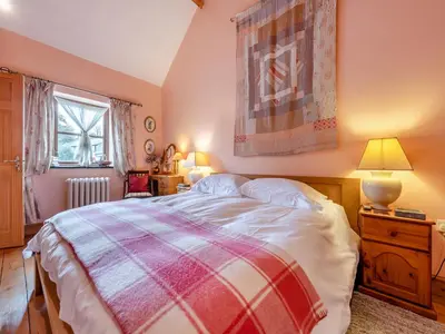 a bedroom with a bed with a plaid blanket at Y Cartws in Llanybydder