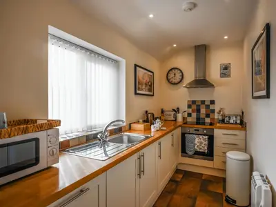 a kitchen with a sink and a microwave at The Old Milking Parlour in Melverley