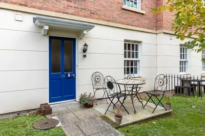 a house with a blue door and a table and chairs at 1-bedroom apartment Shrewsbury town centre in Shrewsbury