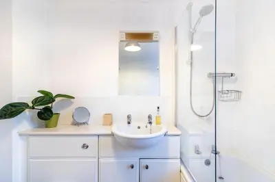 a white bathroom with a sink and a shower at 1-bedroom apartment Shrewsbury town centre in Shrewsbury
