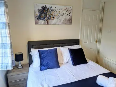a bedroom with a bed with blue and white pillows at Theatre Severn Town House, Parking & Quarry Views in Shrewsbury